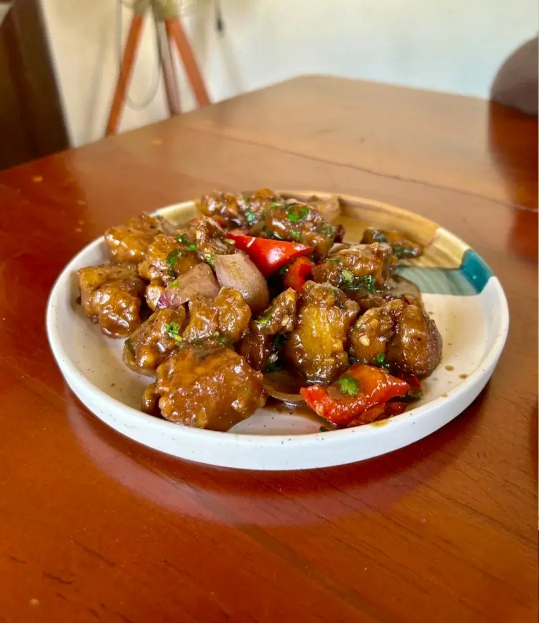 A dish of glazed, dry-fried meat with red and green chilli.